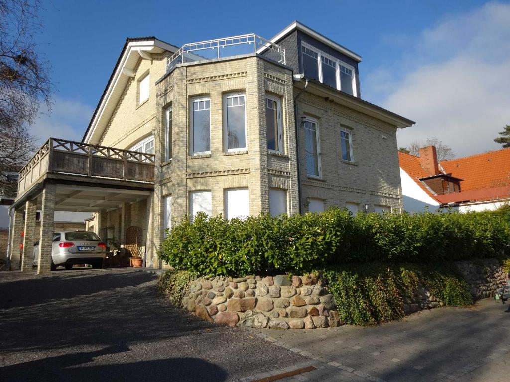 une maison avec un balcon au-dessus dans l'établissement Haus Sonne _ Meer, à Sierksdorf