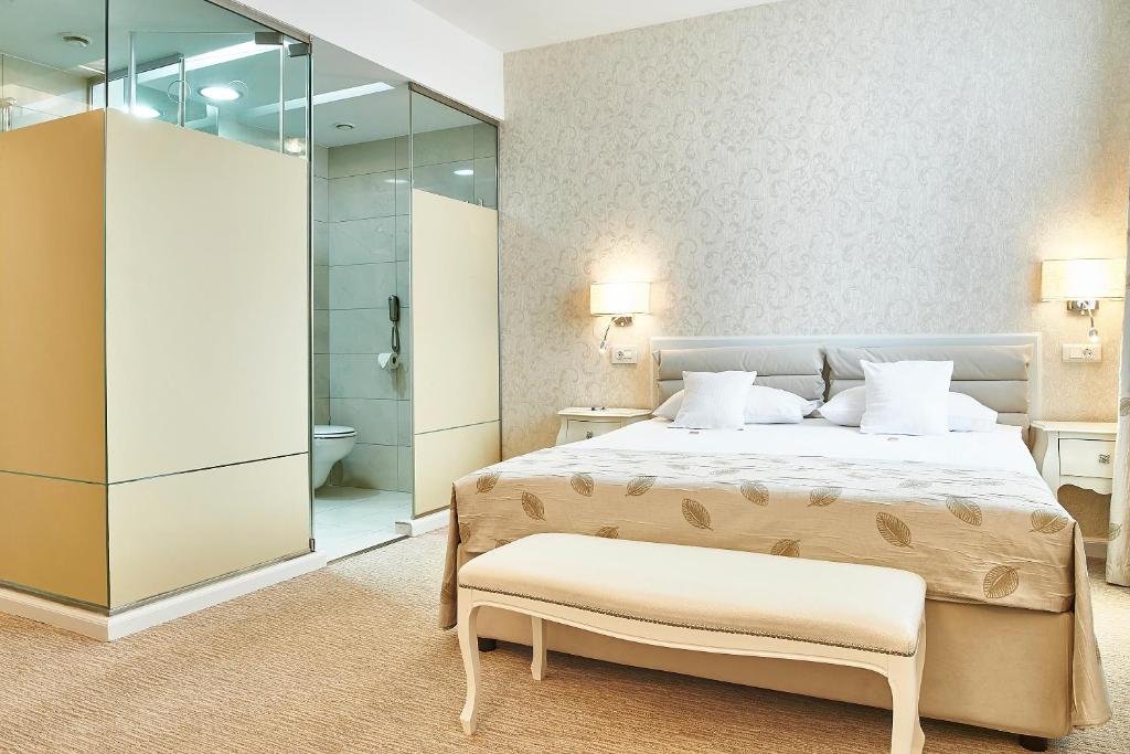 a bedroom with a bed and a bathroom with a shower at Continental Forum Sibiu in Sibiu