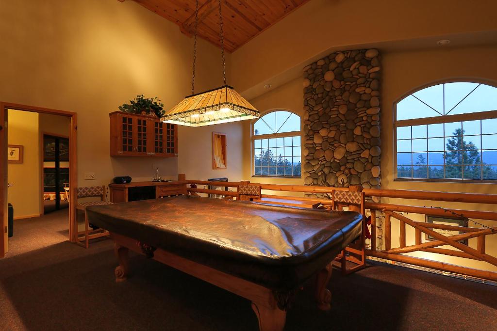 Habitación grande con una gran mesa de madera frente a las ventanas. en Summit Ski-Inn Ski-Out, en Big Bear Lake