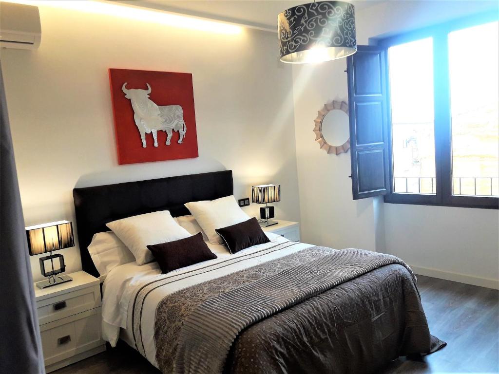 ウベダにあるApartamentos Sol Compañiaのベッドルーム1室(ヤギの絵画が壁に描かれたベッド1台付)
