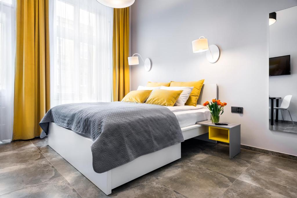 Un dormitorio con una cama con almohadas amarillas y una ventana en Home Sleep Home Przemyska, en Cracovia