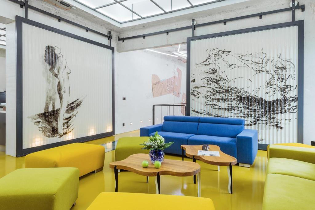 a room with yellow and blue chairs and tables at Smarthotel Nezvalova Archa in Olomouc