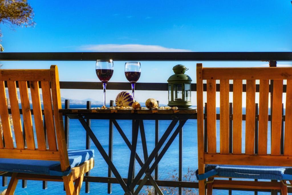 two glasses of wine on a table with two chairs at Seaview apartment in Piraeus