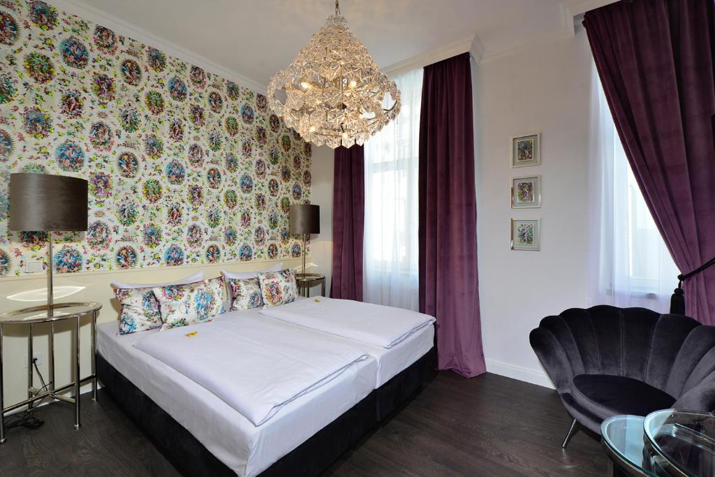 Hotel Domstern في كولونيا: غرفة نوم بسرير وثريا