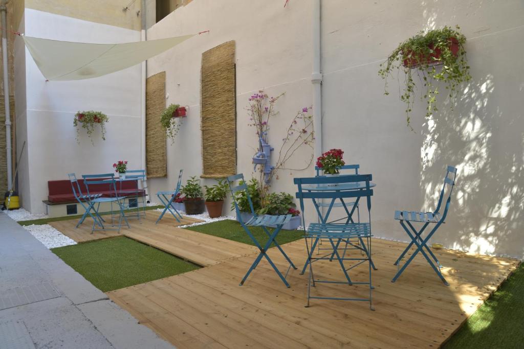 a patio with chairs and tables and potted plants at A mi Manera in Sassari