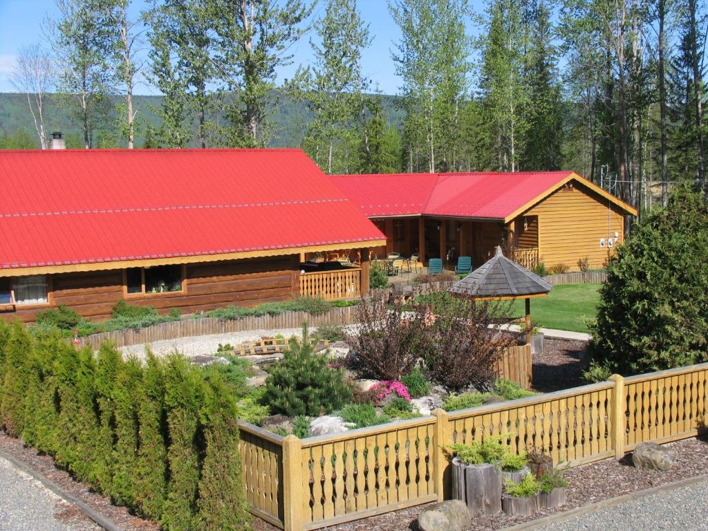 a log cabin with a red roof and a garden at Blue Grouse Country Inn B&B in Clearwater