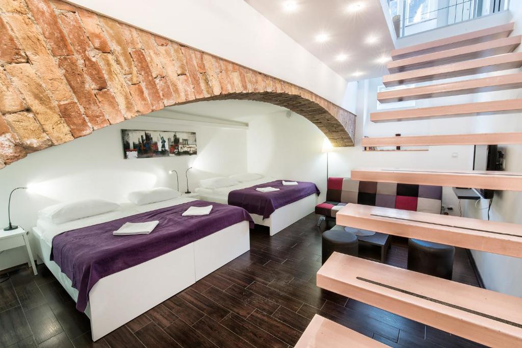 a hotel room with two beds and a staircase at Tia Apartments and Rooms in Zagreb