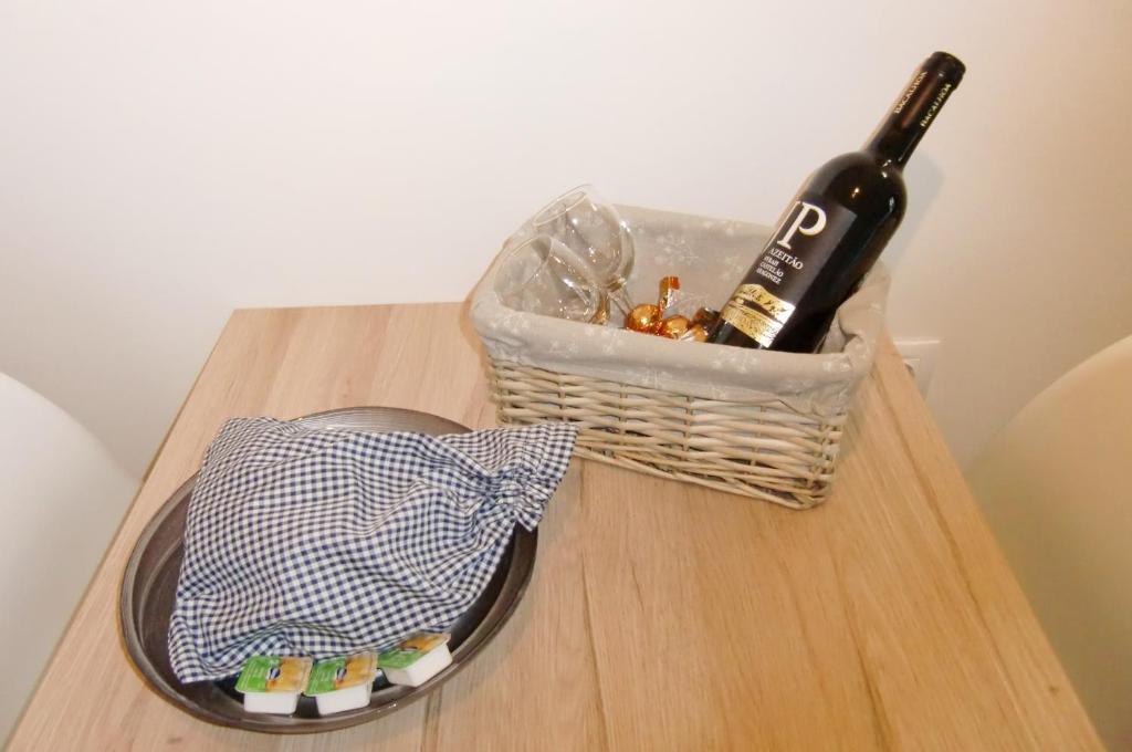a bottle of wine and a basket on a table at The Surf Studio - Ericeira in Ericeira