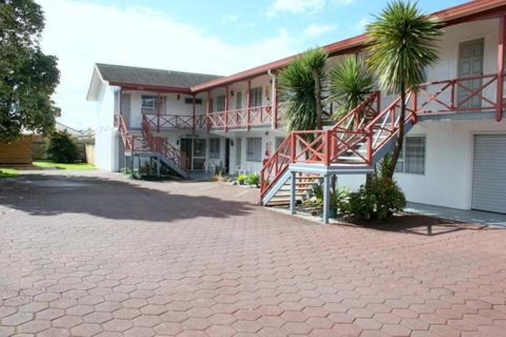 a house with a brick driveway in front of it at Burgundy Rose Motel in Whangarei