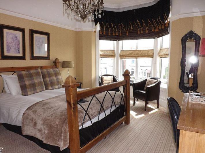 1 dormitorio con cama y lámpara de araña en The Ambassador Townhouse en Southport