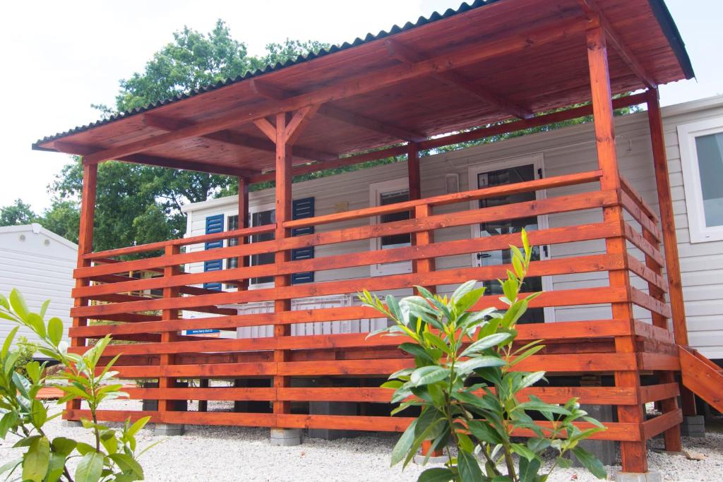 a wooden pergola is attached to a house at Mobile Homes Comfort ELBA Zelena Laguna in Poreč