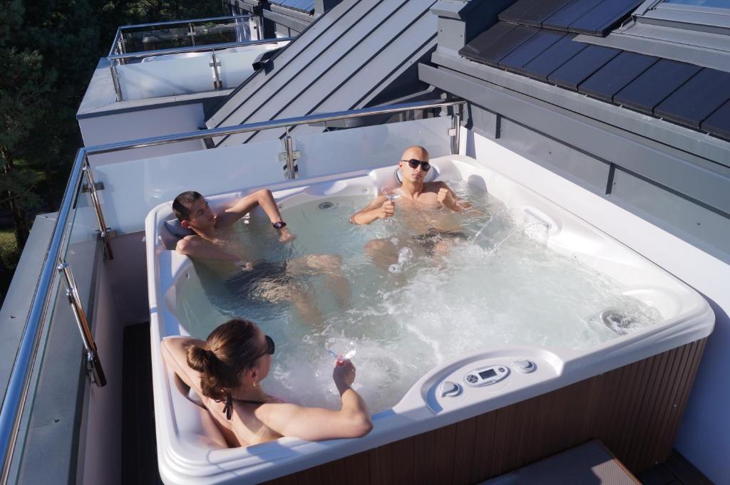 three people in a hot tub on a roof at Wicie Residence in Wicie