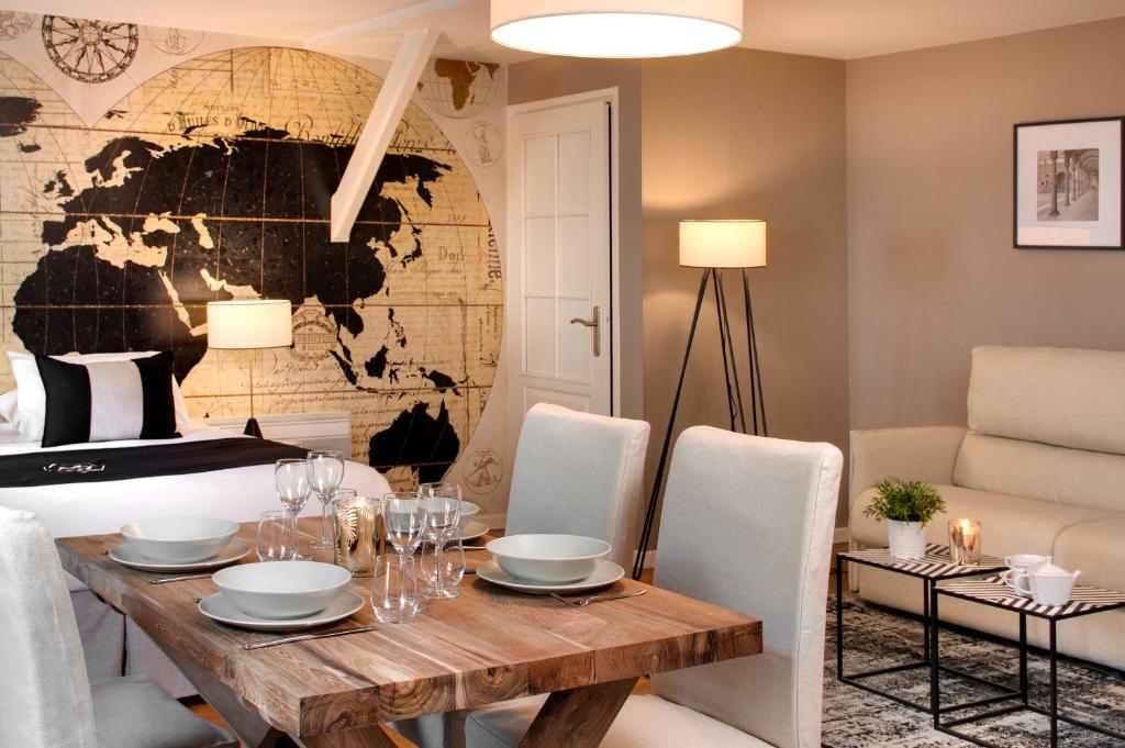 a dining room with a table and a world map on the wall at Hôtel des Ducs in Dijon