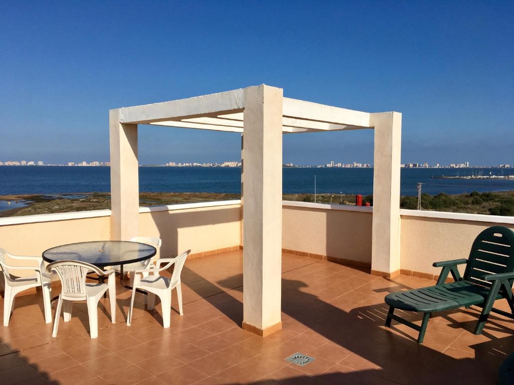 eine Terrasse mit einem Tisch, Stühlen und Meerblick in der Unterkunft Villa Cristal II 5607 - Resort Choice in Los Nietos
