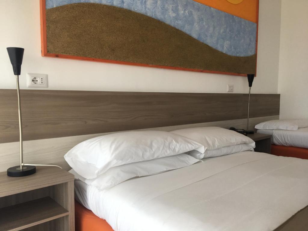 Łóżko lub łóżka w pokoju w obiekcie Hotel Corallo