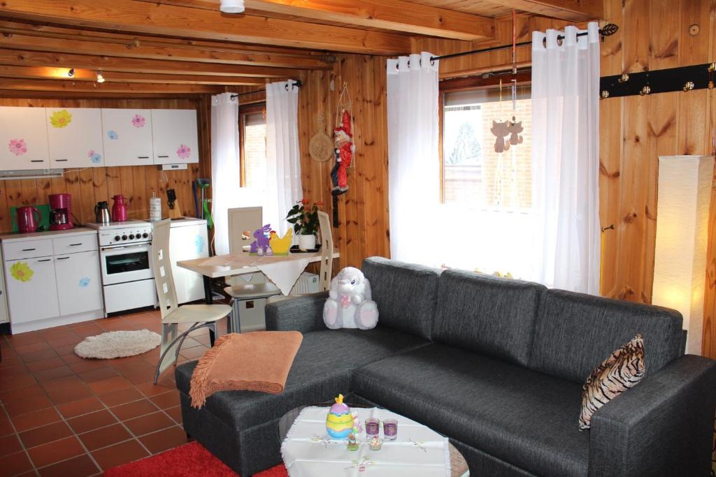 ein Wohnzimmer mit einem Sofa und einer Küche in der Unterkunft Ferienwohnung Maria in Petersfeld
