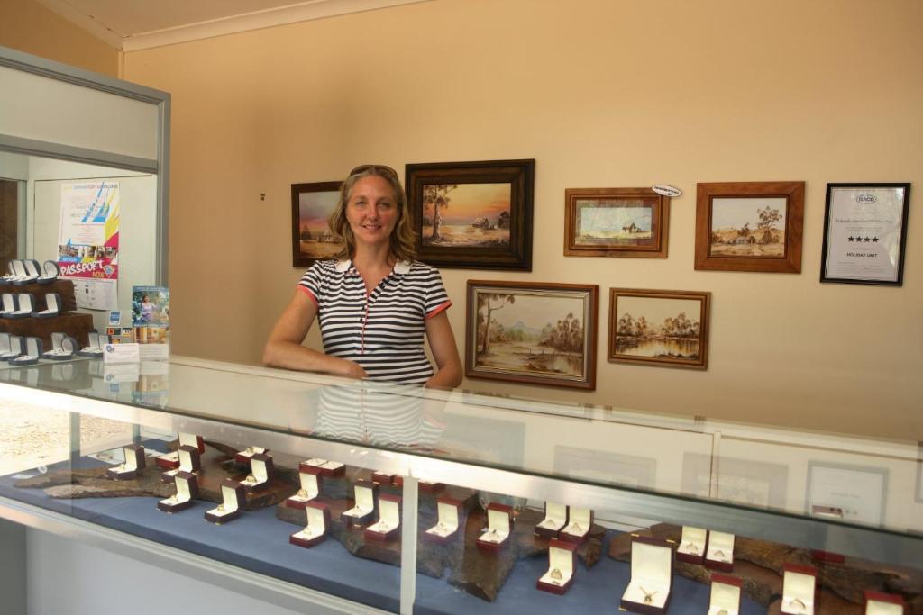 a woman standing in front of a display case of shoes at Rubyvale Motel & Holiday Units - An Adults Only Getaway in Rubyvale