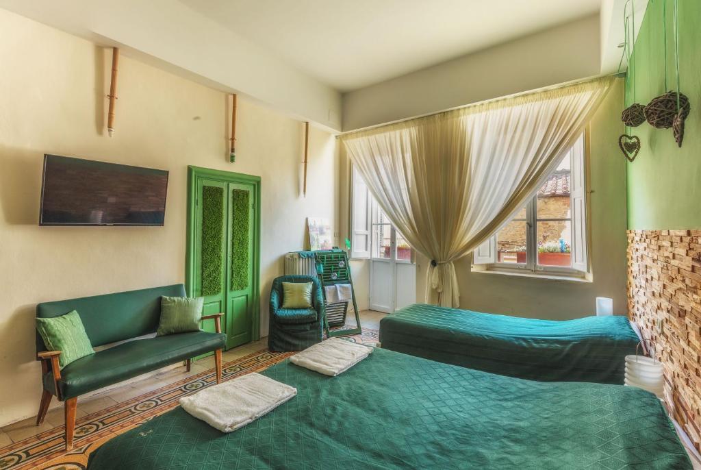 アレッツォにあるGhibellino B&Bのベッドルーム1室(ベッド2台、ソファ、窓付)
