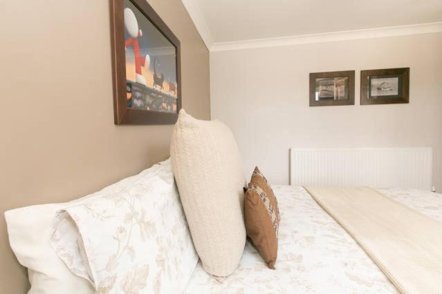 a white bed with two pillows on top of it at Annora House in Berkswell