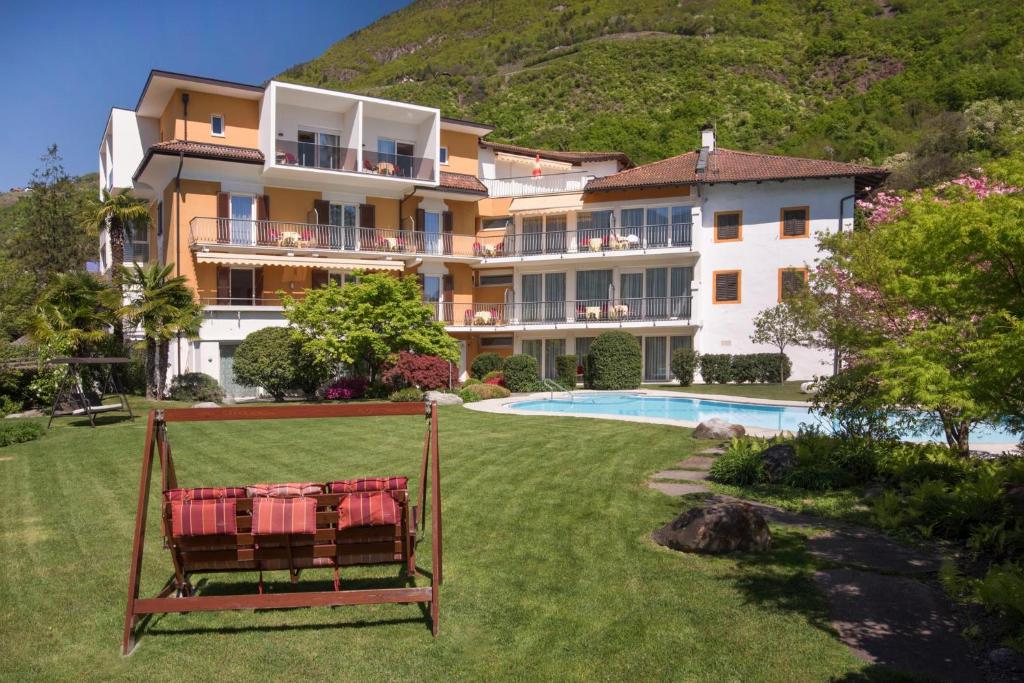 a large building with a yard with a swimming pool at Hotel Garni Günther in Postal