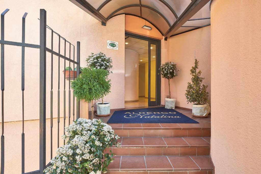 una entrada a un edificio con macetas en Albergo Natalina, en Finale Ligure