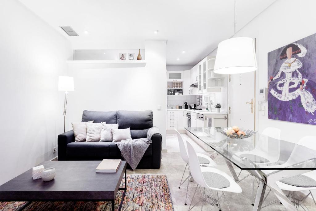 a living room with a black couch and a glass table at Serrano Apartment by Flatsweethome in Madrid