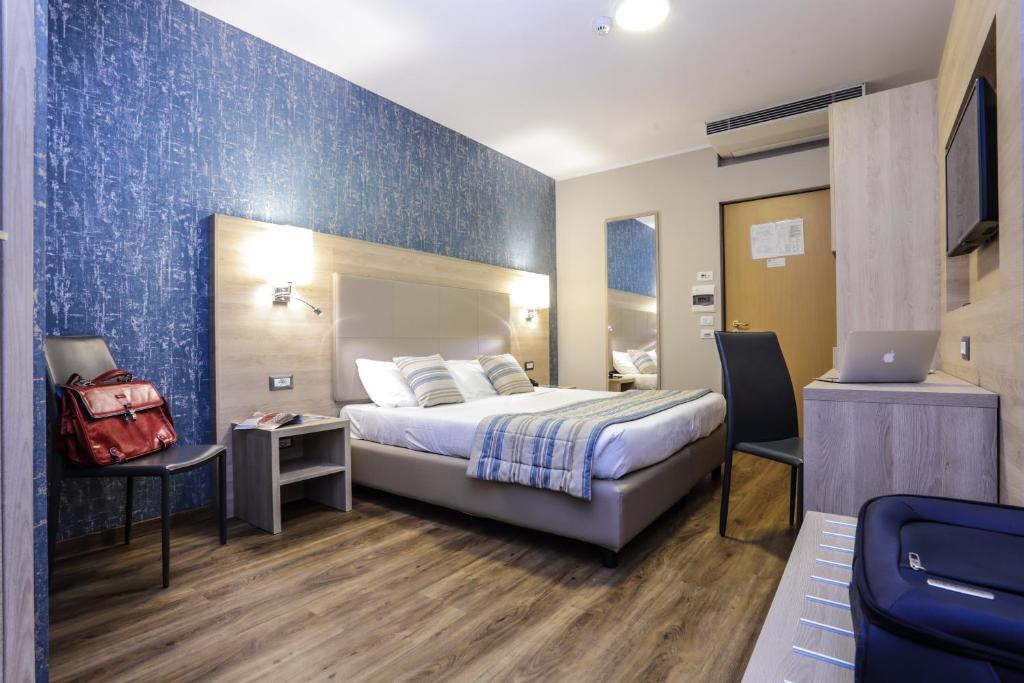 a hotel room with a bed and a laptop computer at Alma di Alghero Hotel in Alghero