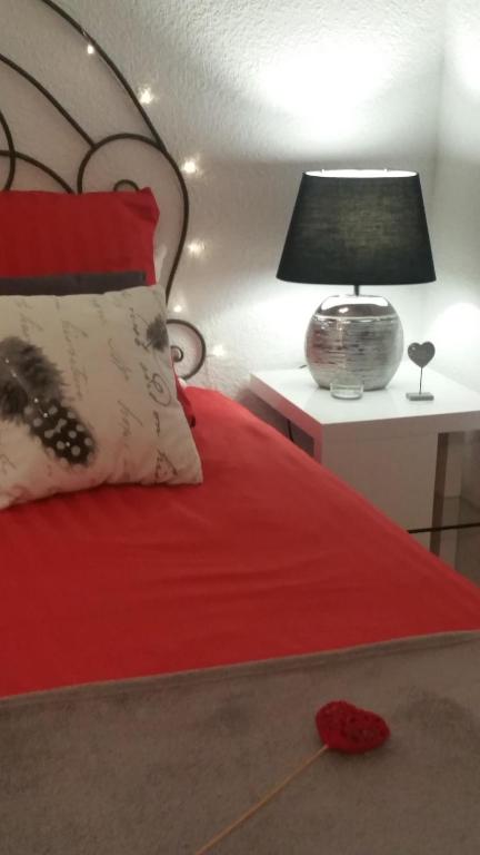 シス・フール・レ・プラージュにあるBel Appartement vue merの赤いベッド(テーブルの上にランプ付)