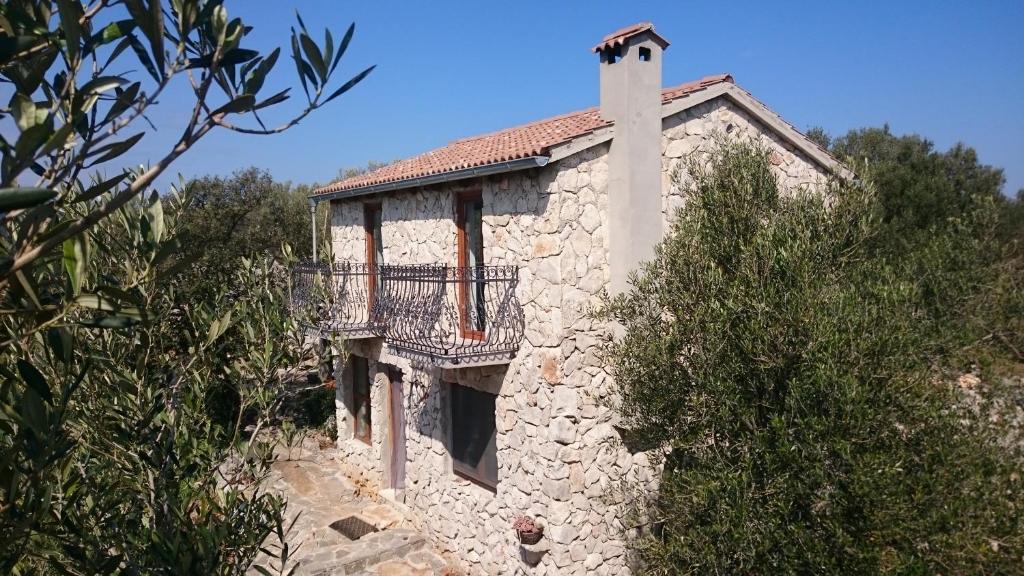 a stone building with a balcony on the side of it at Holiday Home Strpuncina in Luka