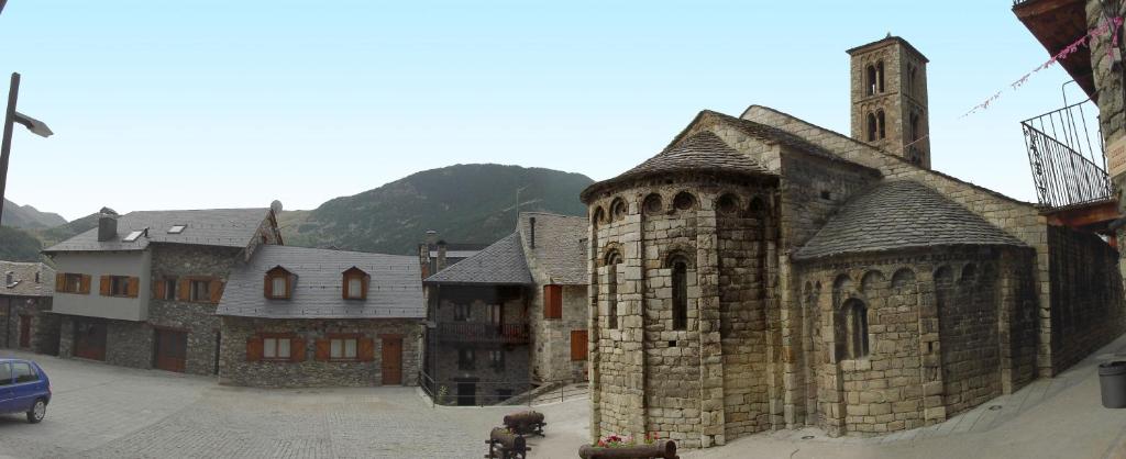 an old stone building with a tower on a street at Casa Valentí in Taull