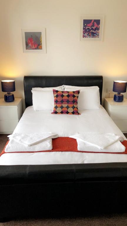a bed with white sheets and pillows and two lamps at The Star Inn in Nottingham