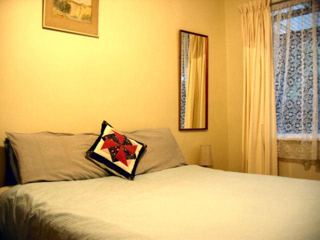 Glow Worm Motel في وايتومو كيفز: غرفة نوم عليها سرير ومخدة