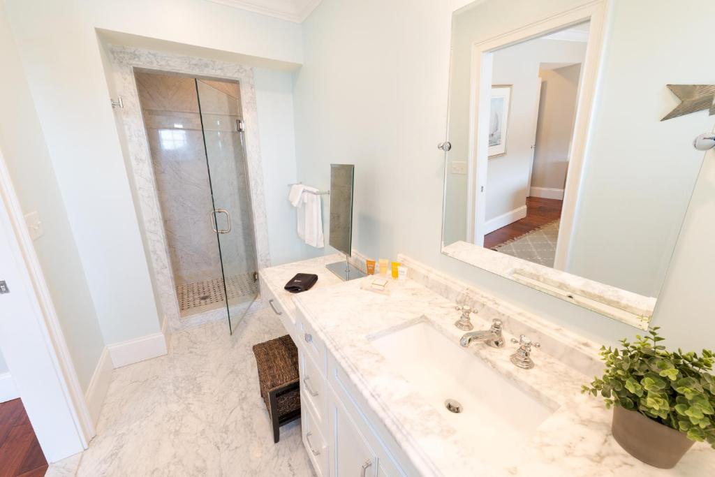 a white bathroom with a sink and a mirror at The Newport Lofts - 543 Thames Street in Newport