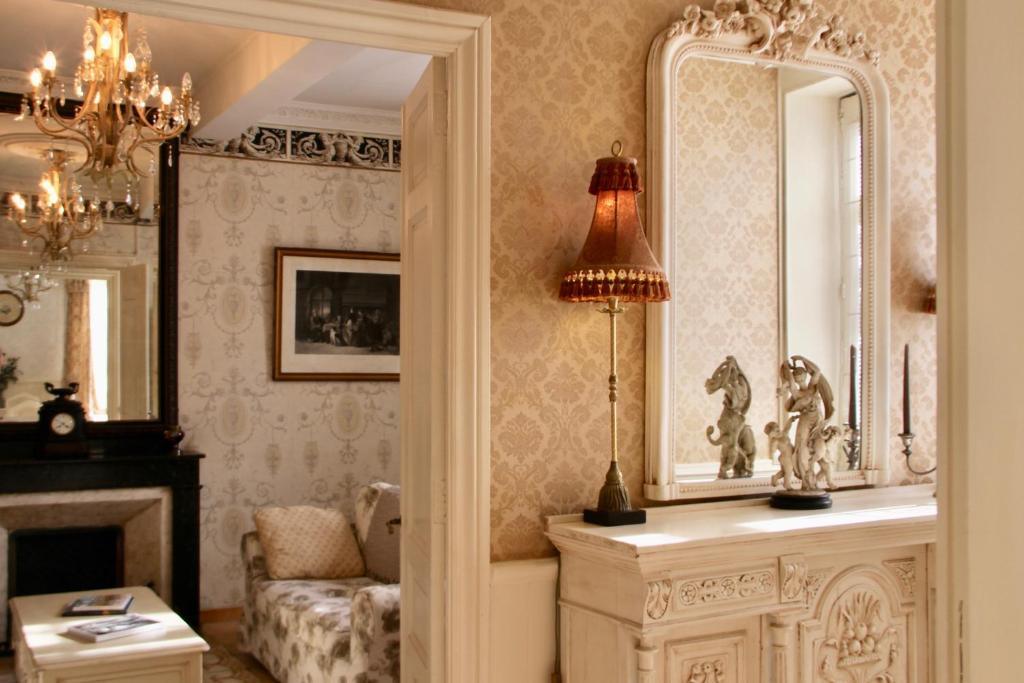 OlonzacにあるSainte-Hélène Chambres d'Hôtes & Appartementのリビングルーム(鏡、ソファ付)
