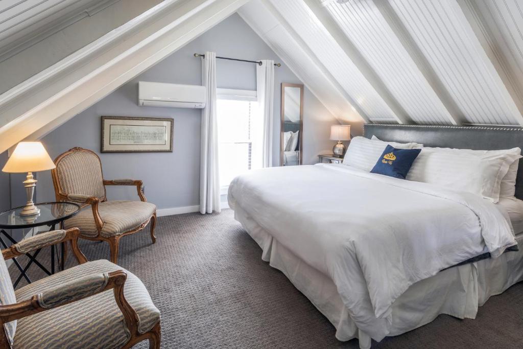 a bedroom with a large white bed and a window at Queen Vic Guest House in Provincetown