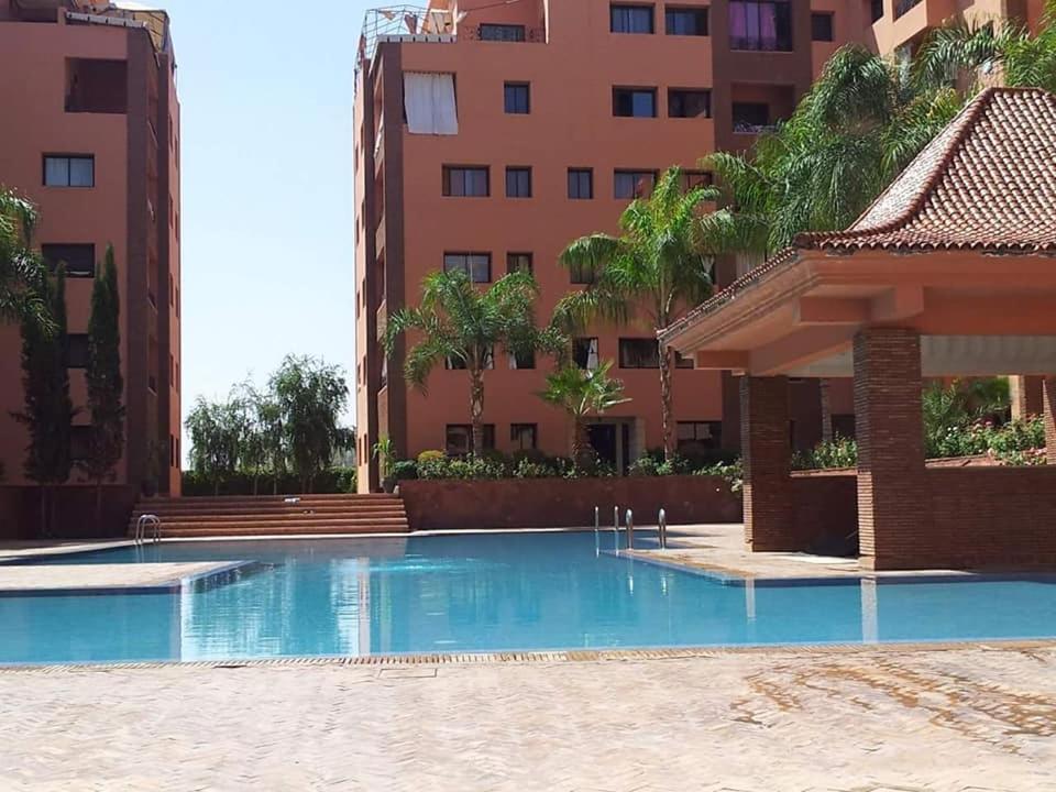 una piscina vacía frente a un edificio en Babylon Appartments, en Marrakech