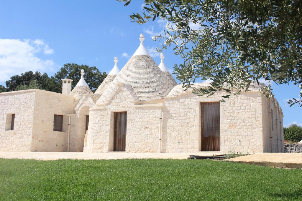 a building with turrets and grass in front of it at I Trulli del Mulino in Locorotondo