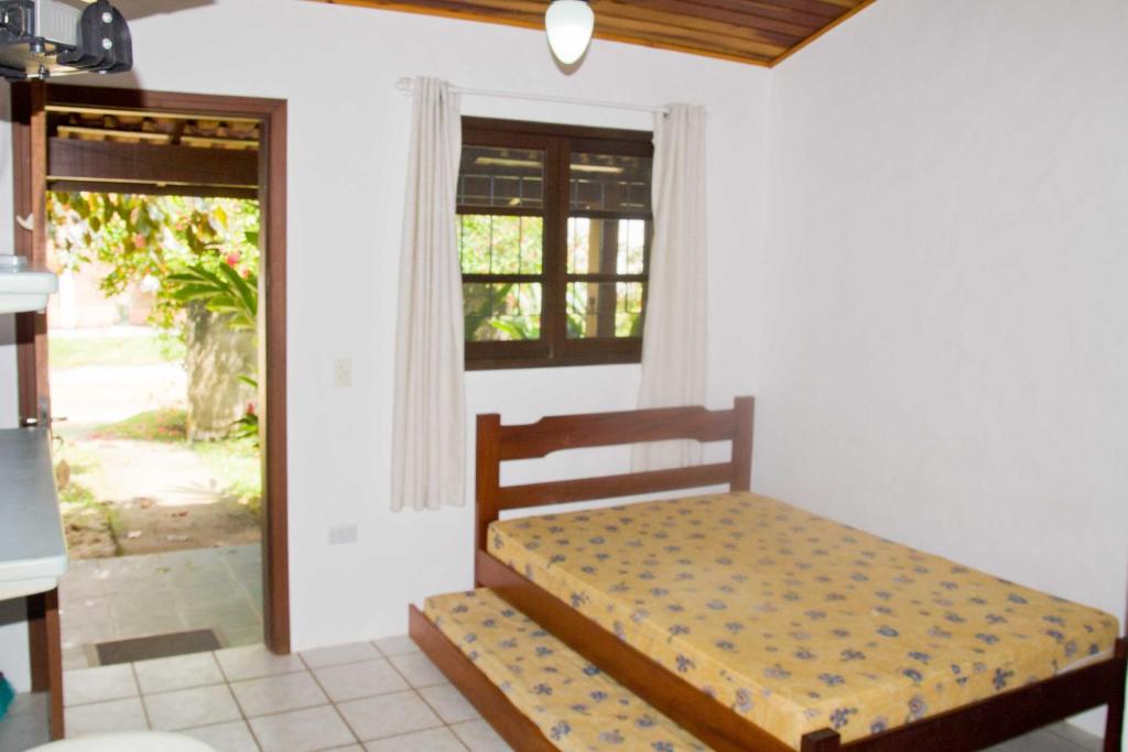 una camera con un letto in una stanza con una finestra di Chalés Mariah a Ubatuba