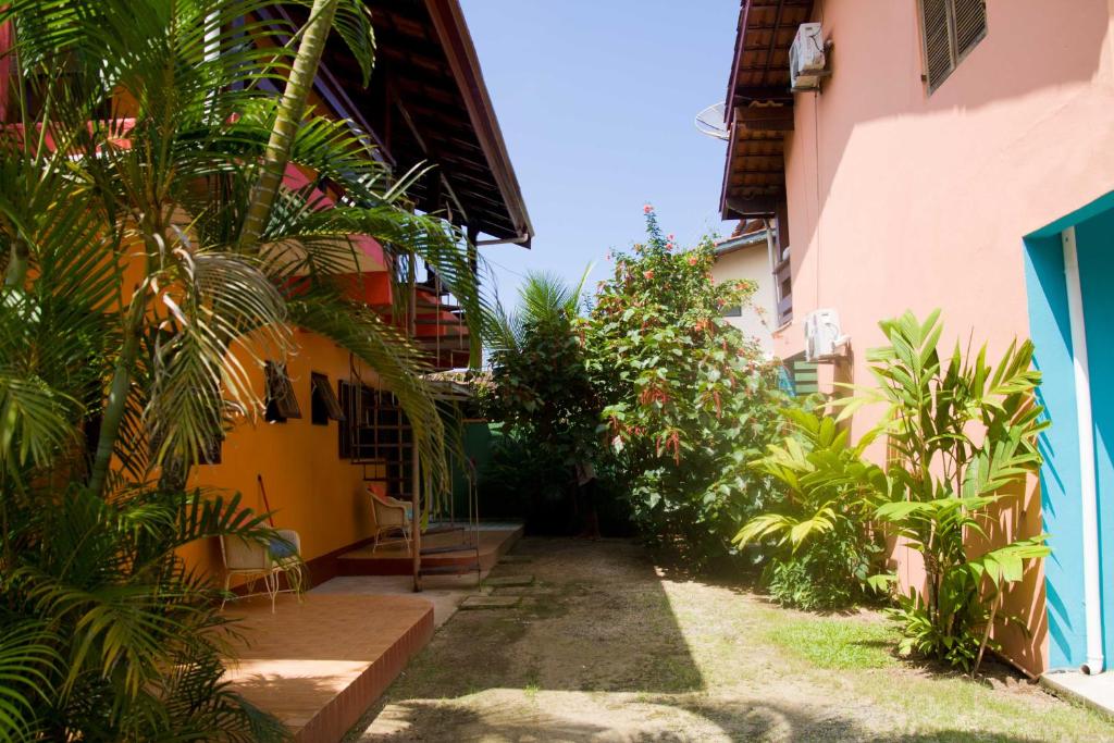 a courtyard of a building with trees and plants at Chalés Mariah in Ubatuba