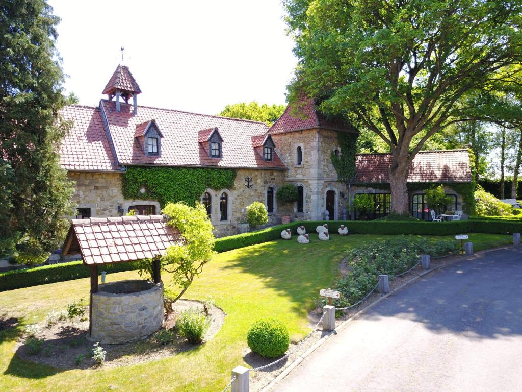 una grande casa in pietra con un cortile con un sentiero di La Bergerie de Lives a Namur