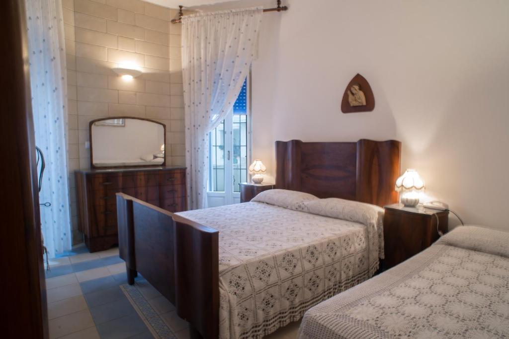 a bedroom with two beds and a mirror at Villetta Rossella Mancaversa in Marina di Mancaversa