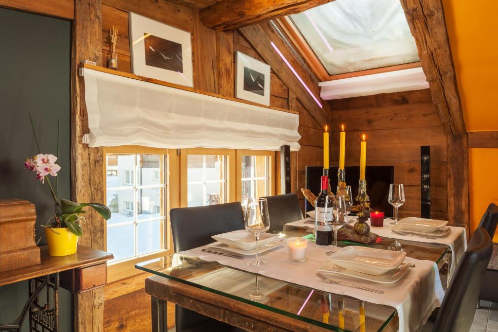 ein Esszimmer mit einem Tisch, Stühlen und einem Fenster in der Unterkunft Chalet Schtuba in Zermatt