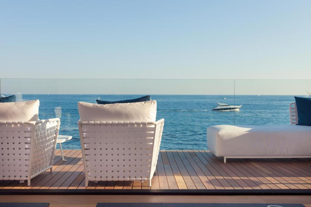 een terras met stoelen en een bed en een boot in het water bij Luxury Sperone Residence in Novigrad Istria
