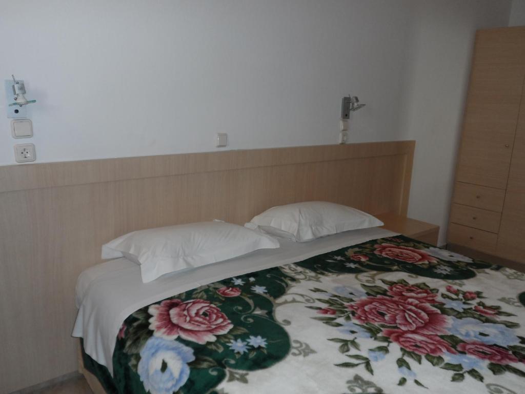 a bed with two pillows and a blanket on it at Villa Giorgos in Kefalos