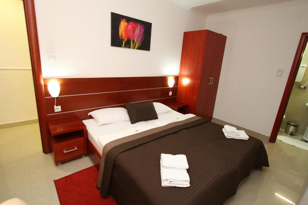 1 dormitorio con 1 cama con 2 toallas en Guesthouse Villa Inn, en Subotica