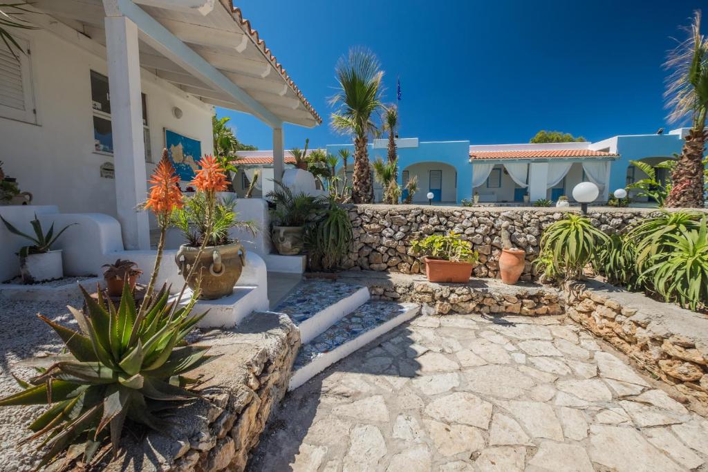 un patio con macetas y una pared de piedra. en Albergo isola mia, en Favignana