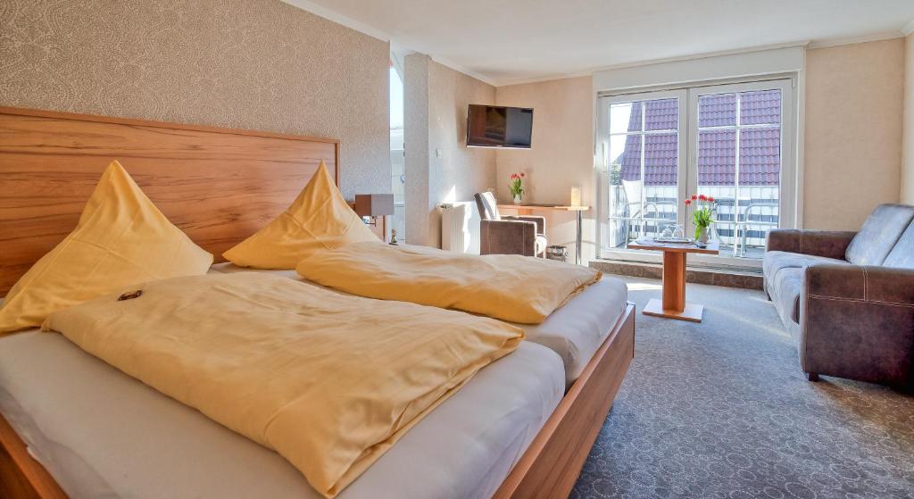 a bed with pillows on it in a living room at Hotel Peters in Neuharlingersiel