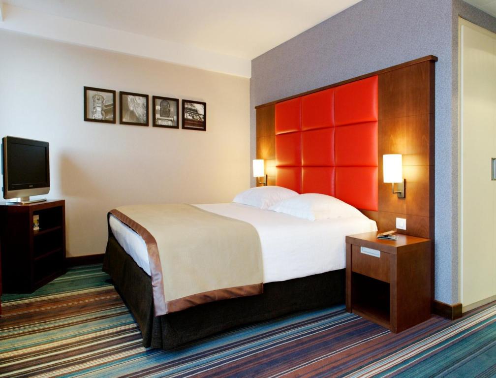 a hotel room with a bed and a flat screen tv at New Hotel Charlemagne in Brussels