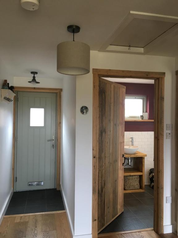 a hallway with a door and a sink at Cosy Cottage in Glencoe