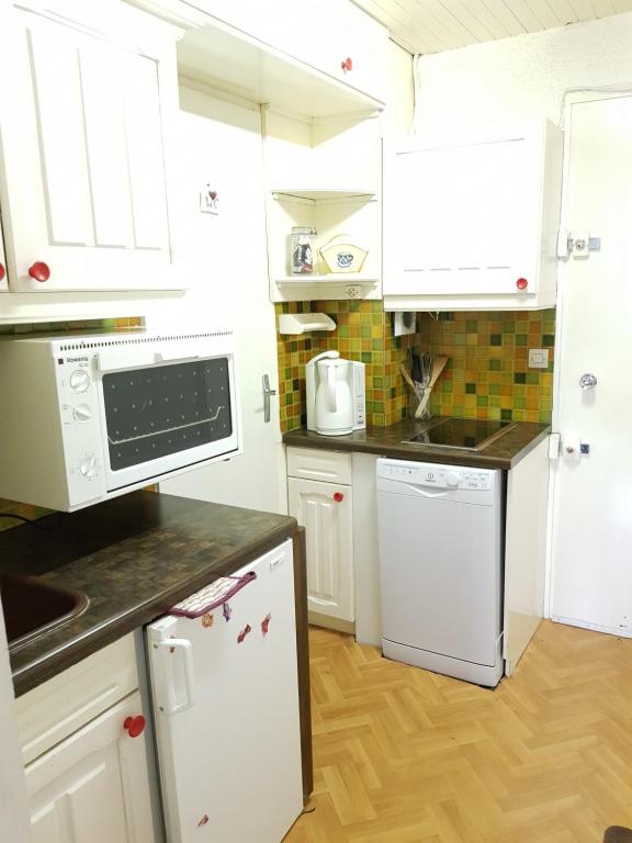 una cocina con armarios blancos y electrodomésticos blancos en Boost Your Immo Vars Le Melezen 36 en Vars